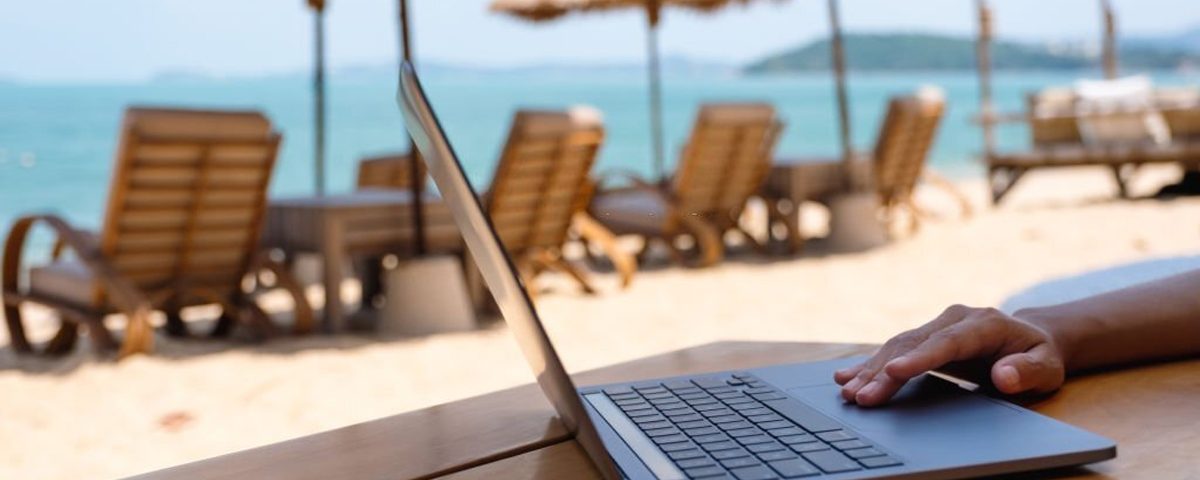 Woman working on laptop on the beach