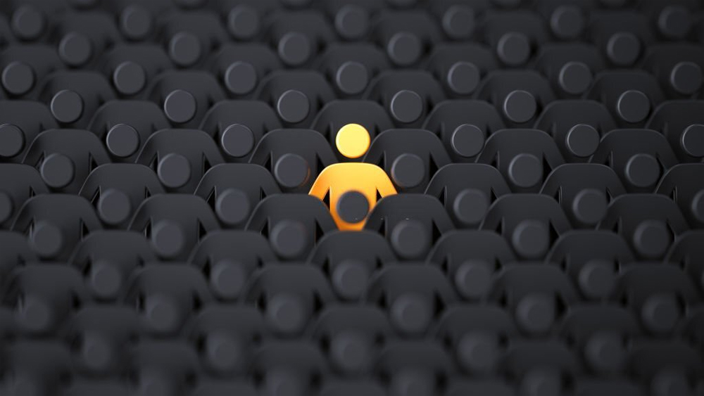 Yellow human shape among dark ones standing out of crowd