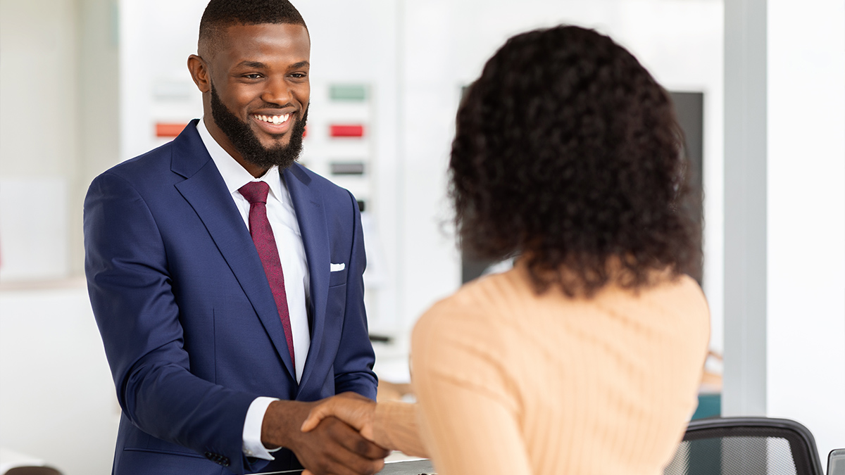 Smiling manager shaking hands with female customer