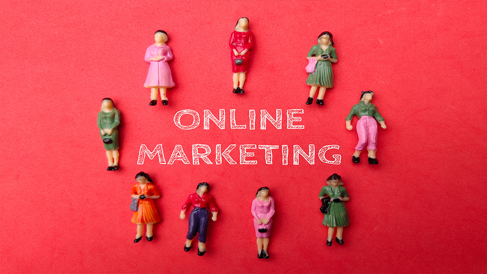 Miniature businesswomen with the word online marketing