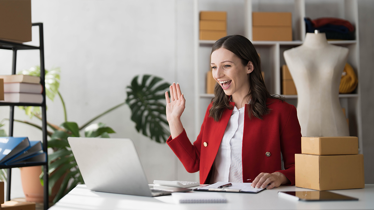 Smiling business owner working on laptop for live stream