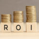 ROI word in wooden blocks with coins stacked