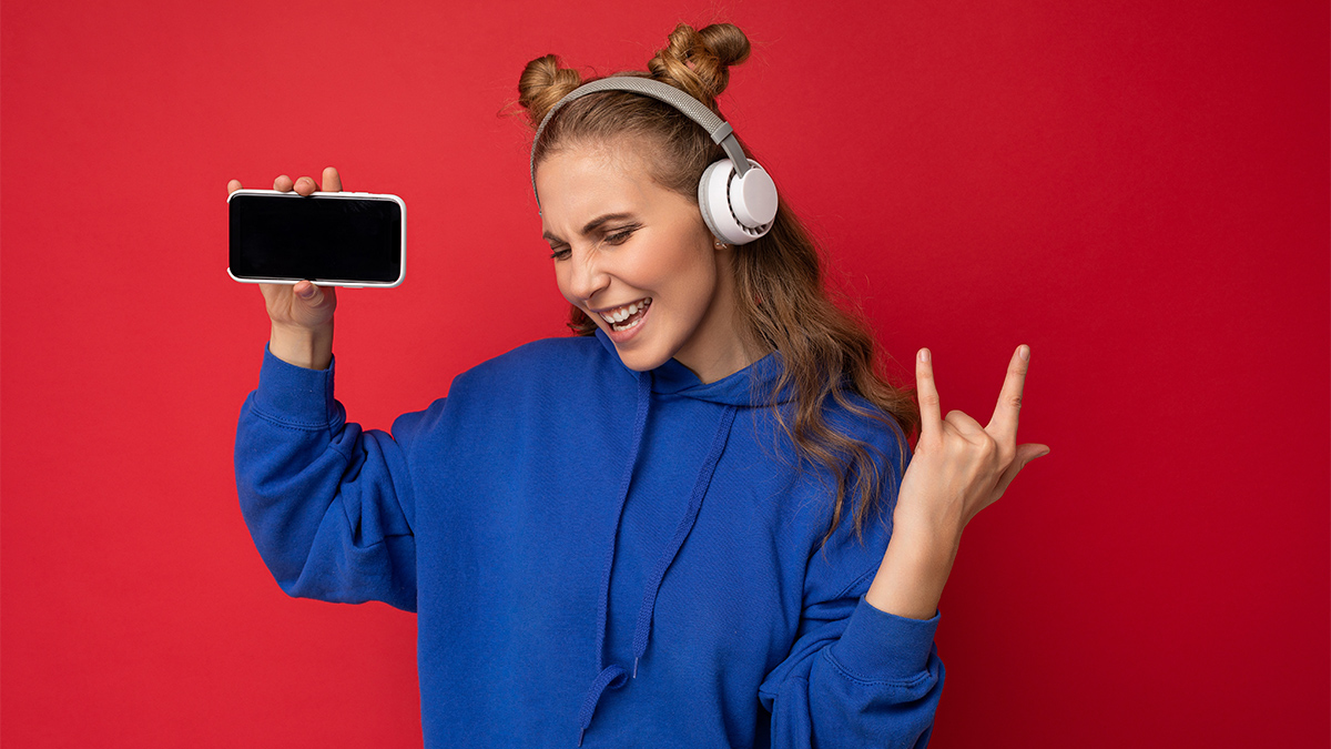 Attractive smiling young woman listening to music