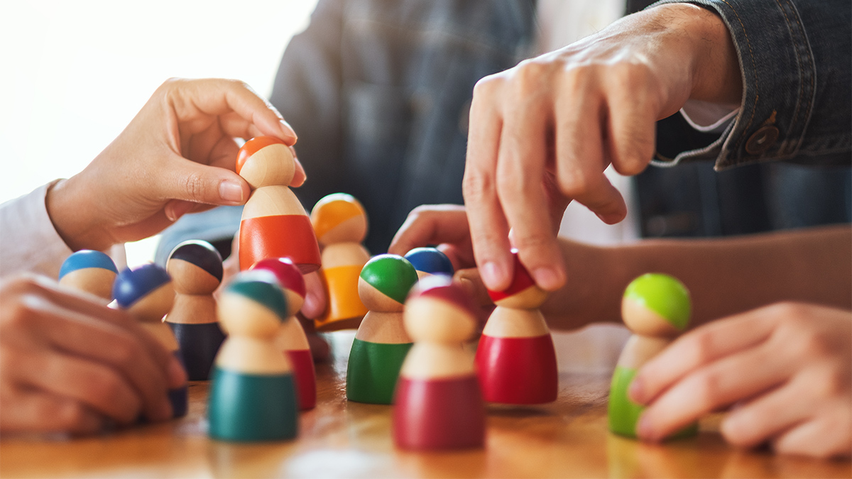 People choosing and picking up wooden game pieces