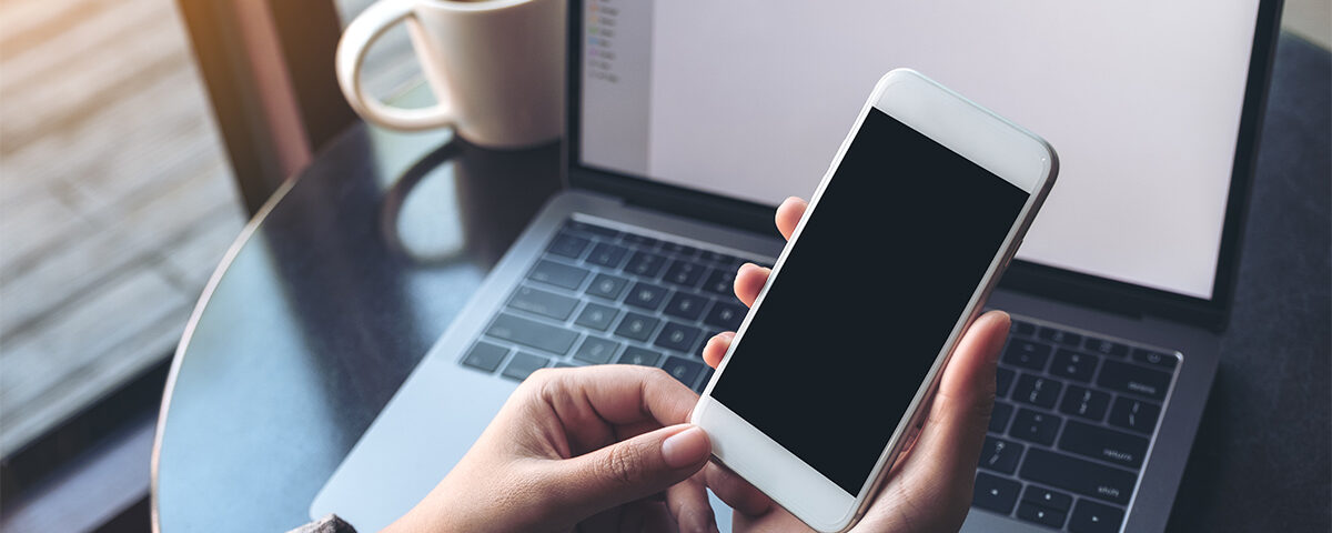 Business woman holding mobile phone with blank display