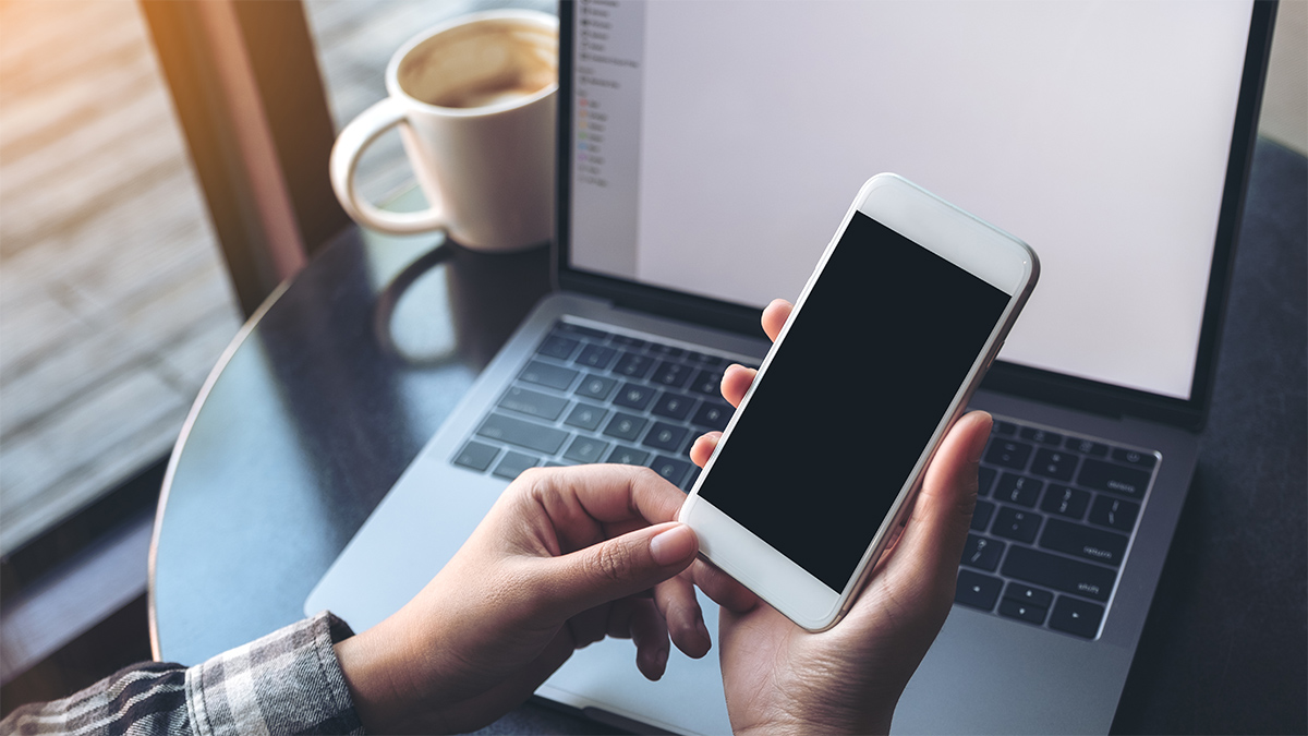 Business woman holding mobile phone with blank display