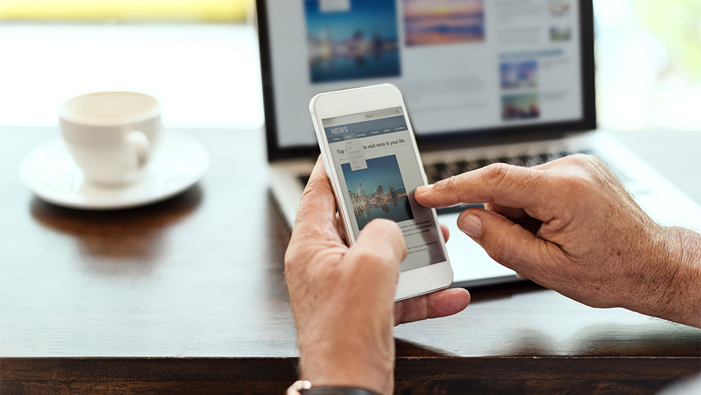 Man using mobile phone checking news on a website