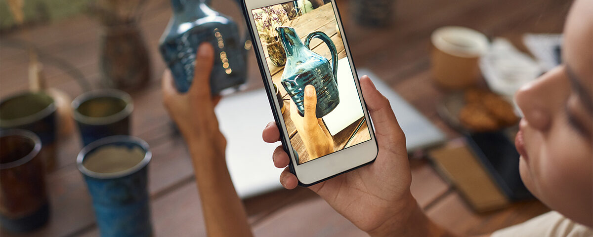 Woman is taking photo of ceramic vase