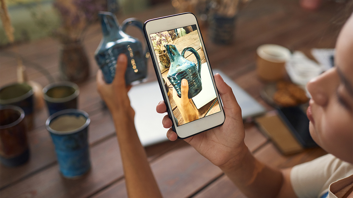 Woman is taking photo of ceramic vase