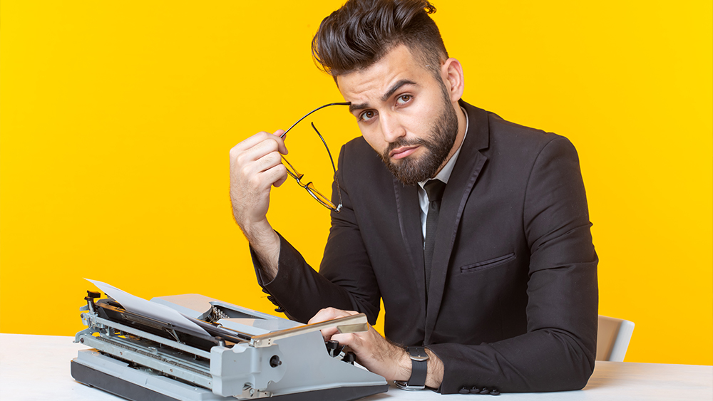 Young tired male content writer typing something