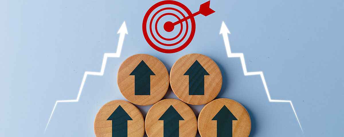 Business growth success achievement concept shown with up arrows on the wooden circles getting closer to the target sign