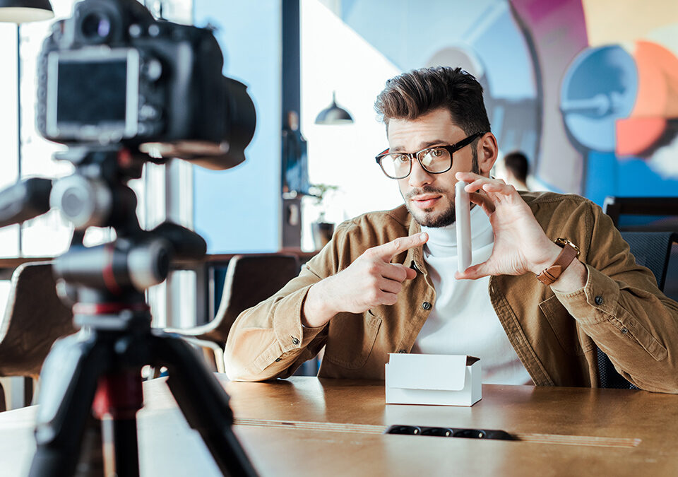 Male blogger unboxing a product in front of a camera