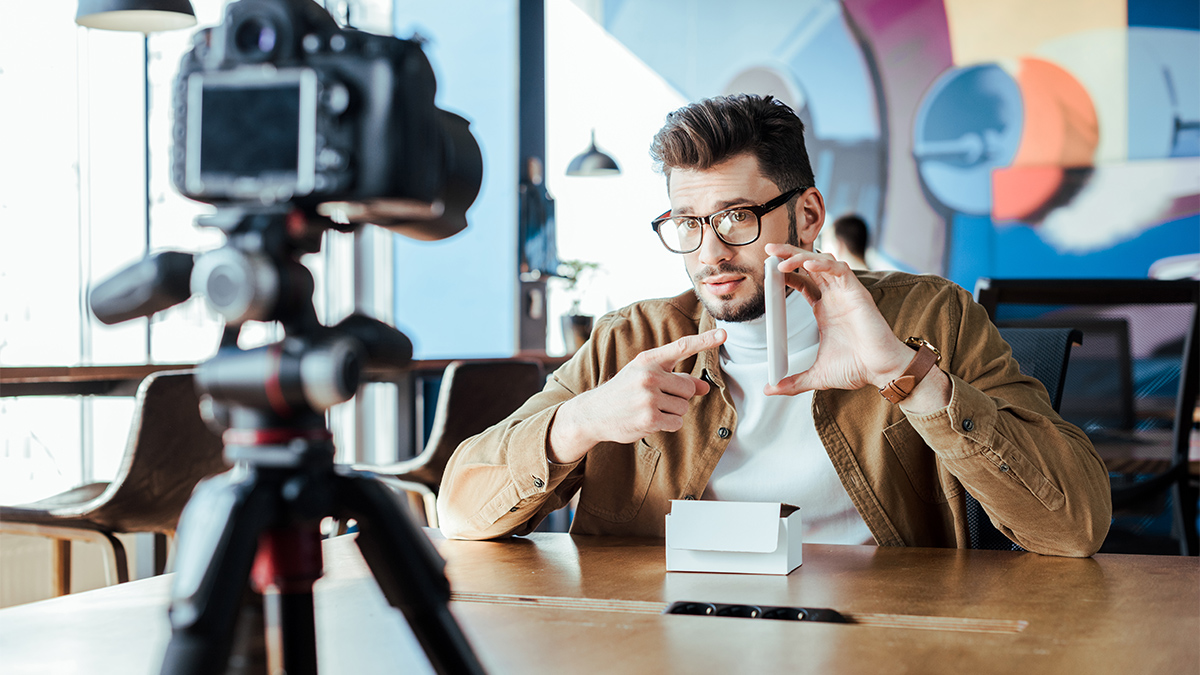 Male blogger unboxing a product in front of a camera