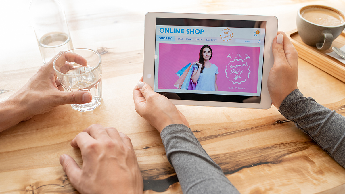 Young woman holding a digital tablet and looking at an online shop