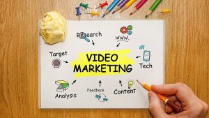 Businessman writing video marketing concept notebook
